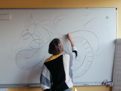 Une élève dessine un dragon grand comme une vallée
